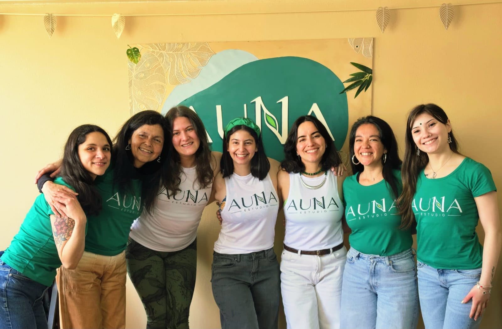 El equipo de AUNA Estudio en la sala, frente al logo del estudio